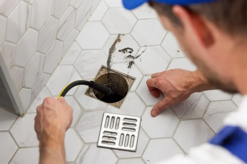 Plumber clearing a blocked drain line
